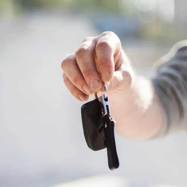 Une main tend des clés de voiture